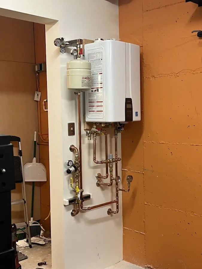Plumbing technician inspecting water heater connections in West Bountiful